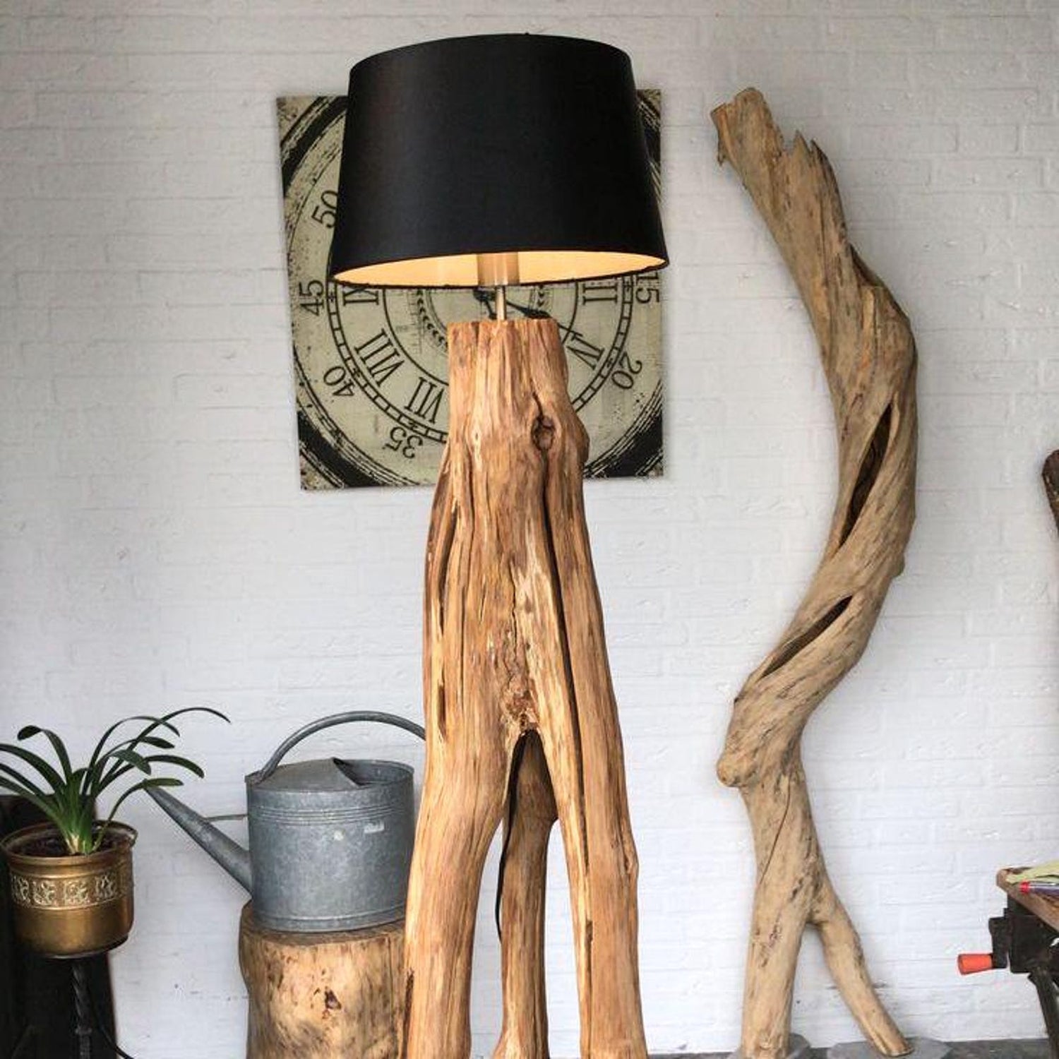 A rustic natural‑wood floor lamp made from a tree trunk, styled in a corner with a black lampshade combining organic texture with warm ambient lighting in minimalist or farmhouse interiors-1