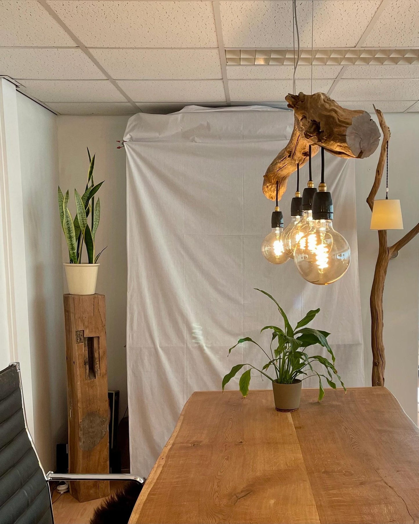 A rustic driftwood ceiling lamp crafted from natural wood branches, suspended by cords and featuring exposed warm-tone bulb lights—ideal for bringing organic farmhouse charm to indoor spaces-2