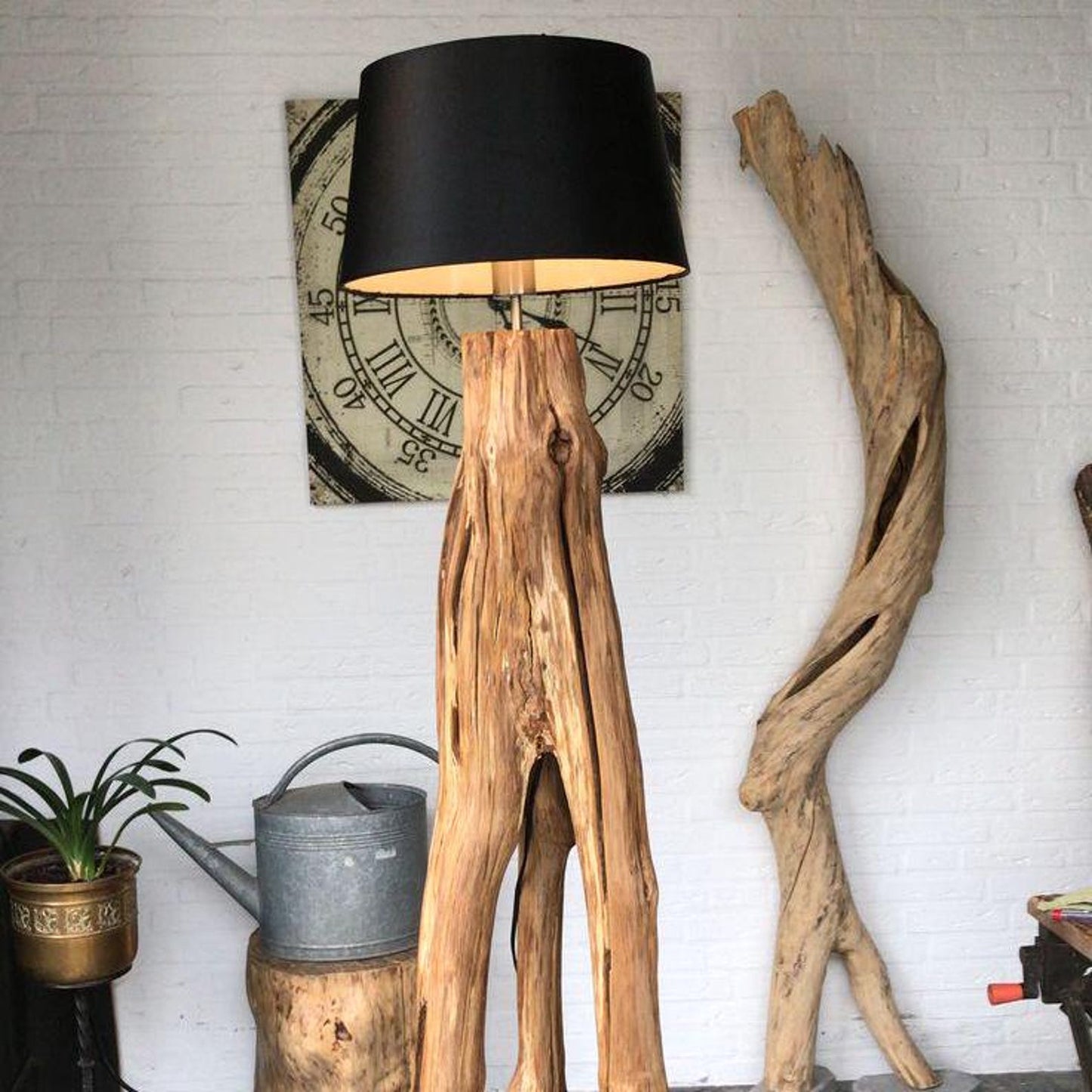 A rustic natural‑wood floor lamp made from a tree trunk, styled in a corner with a black lampshade combining organic texture with warm ambient lighting in minimalist or farmhouse interiors-1