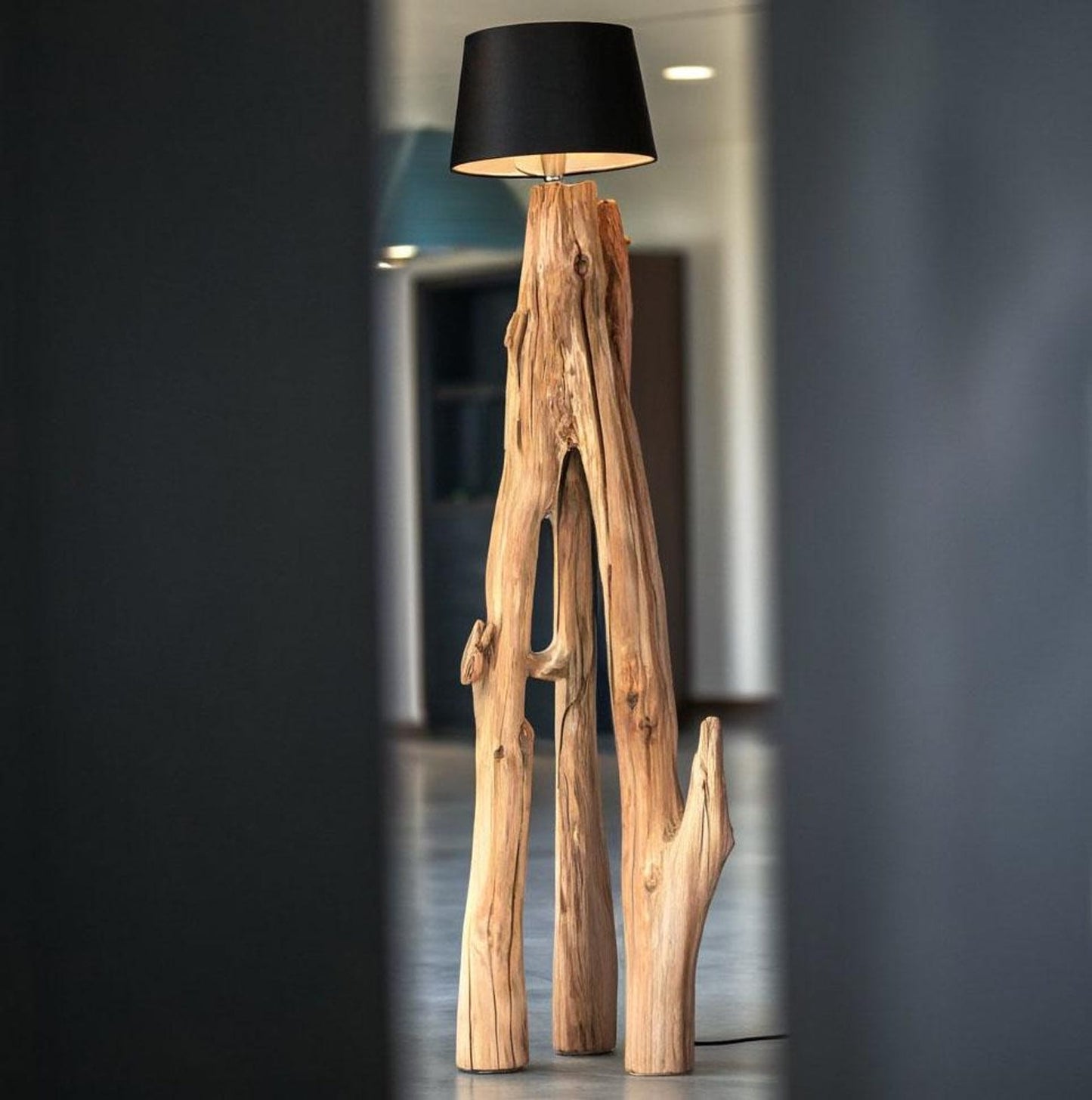 A rustic natural‑wood floor lamp made from a tree trunk, styled in a corner with a black lampshade combining organic texture with warm ambient lighting in minimalist or farmhouse interiors-2