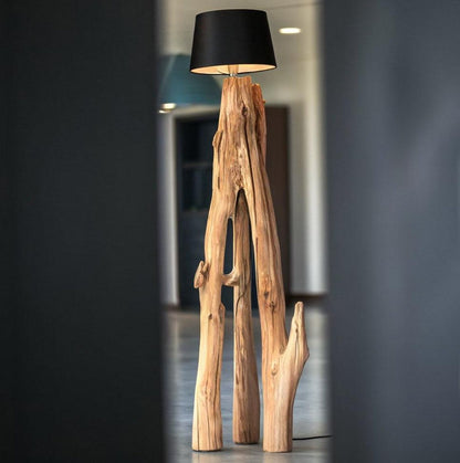 A rustic natural‑wood floor lamp made from a tree trunk, styled in a corner with a black lampshade combining organic texture with warm ambient lighting in minimalist or farmhouse interiors-2