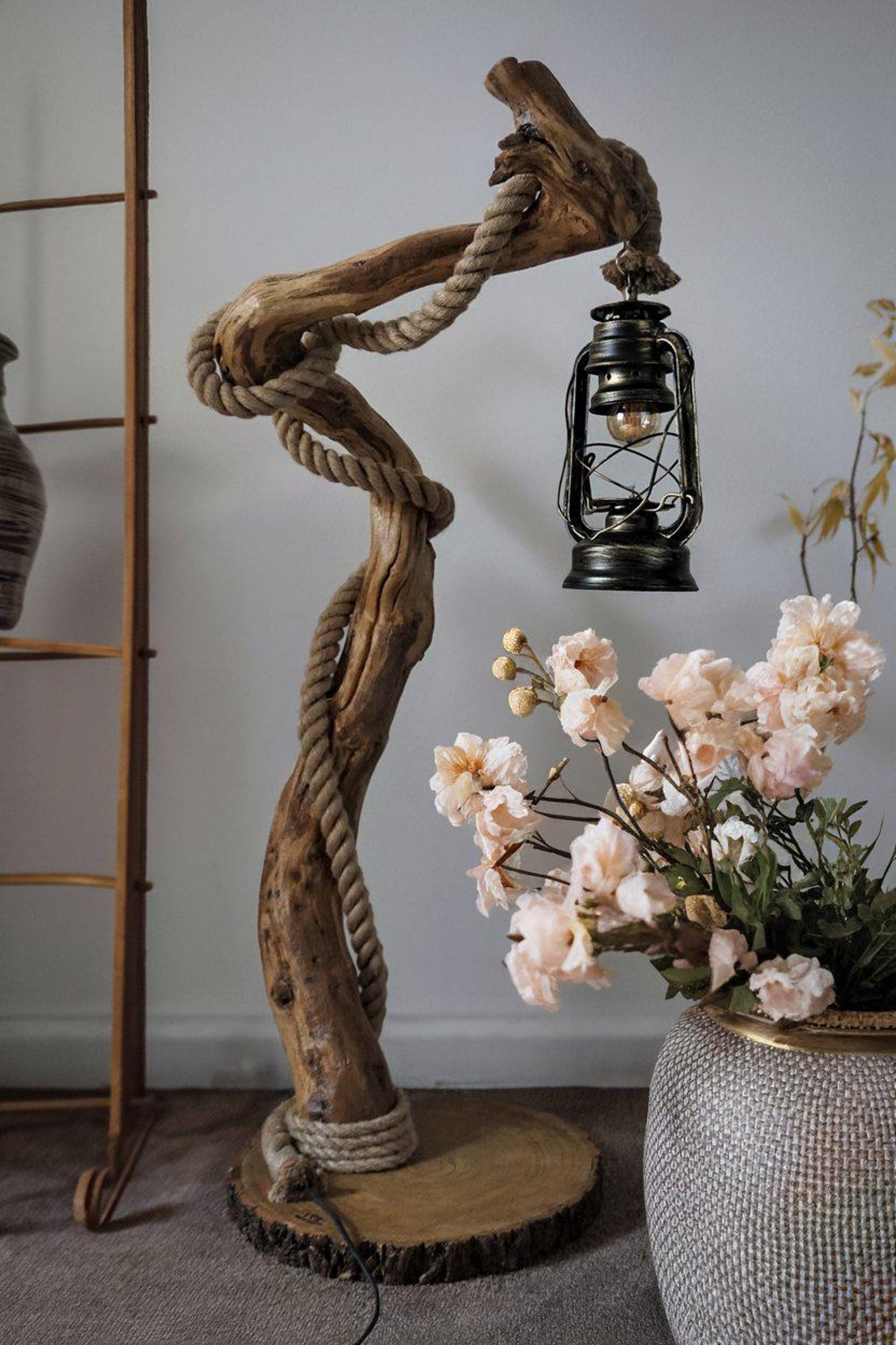 A handcrafted rustic driftwood floor lamp with natural wood base and a beige linen shade, positioned in a living room corner creating warm ambient lighting perfect for both home and office settings-4